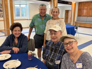 Photo of 5 people around a table.